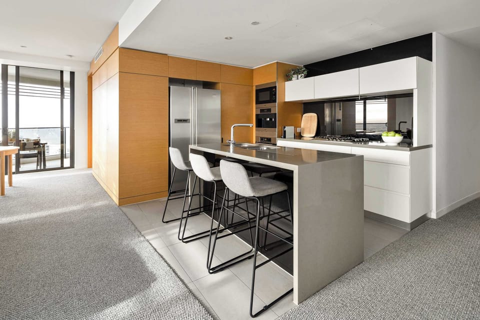 Sleek kitchen with stone benches, gas cooking and plenty of prep space.