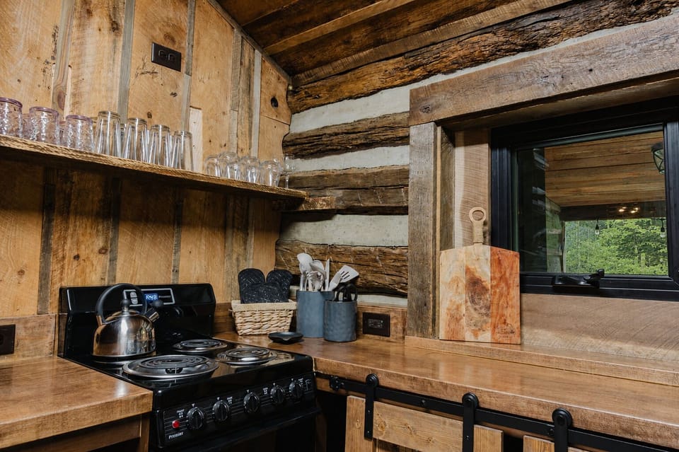 Rustic cabin kitchen with log walls, warm wood finishes, and cozy charm