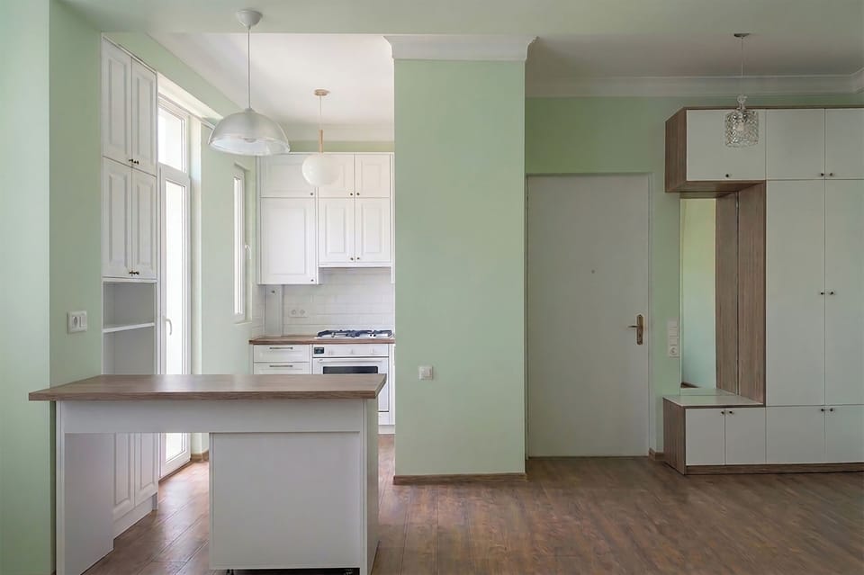 Kitchen just behind the breakfast bar.  A glass door leads to a balcony. 