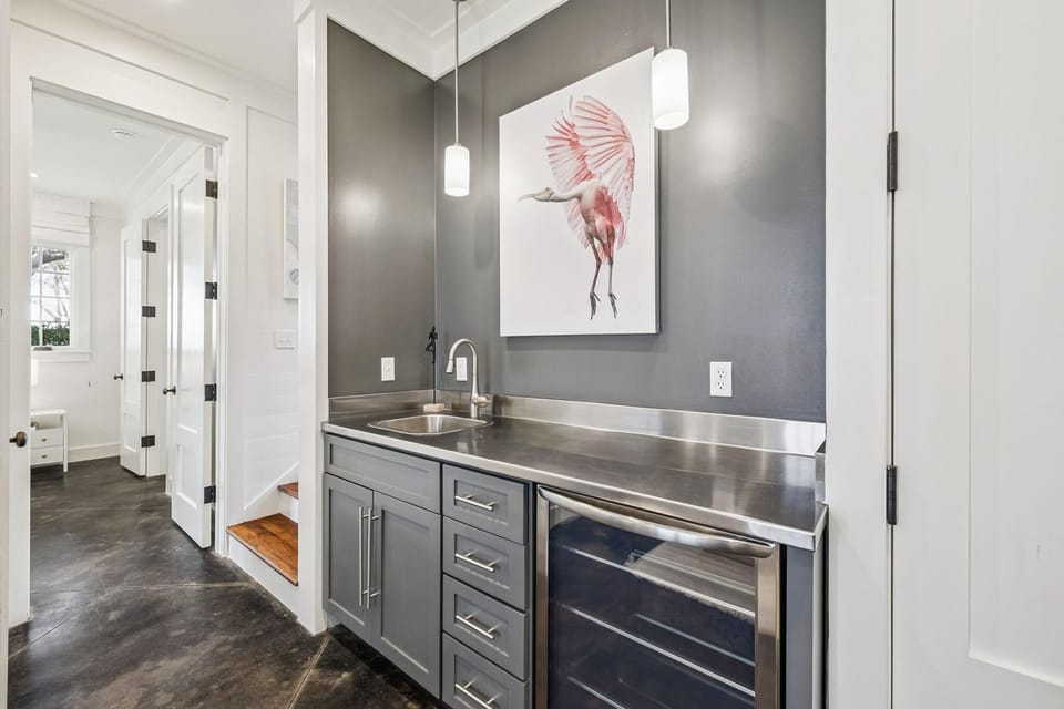 Sleek wet bar with stainless steel counters and wine fridge