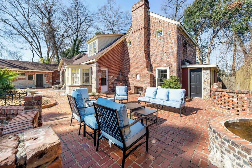 Gather your group on this massive, historic brick patio featuring a full set of plush, light-blue cushioned seating designed for hours of conversation.