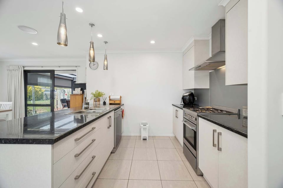 Fully equipped chef's kitchen with dishwasher, gas range and pendant lighting — spacious holiday home in Rotorua NZ