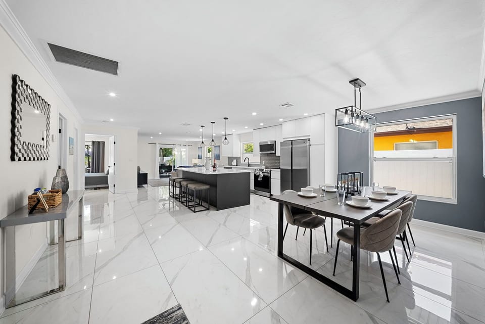 Open plan dining, kitchen island, and living area all in one view.