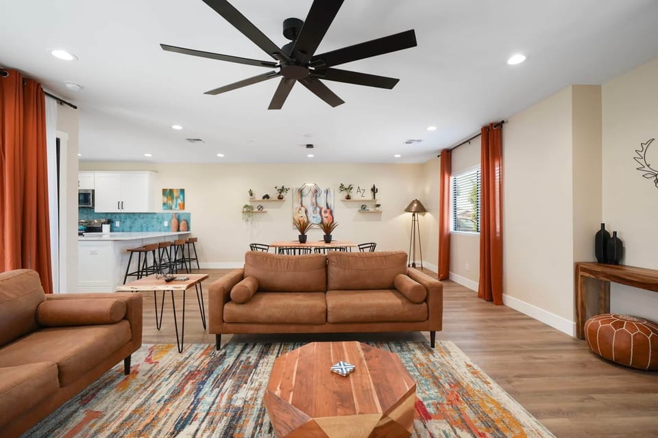 Bright, open-concept living space featuring stylish leather seating and desert-inspired decor. 