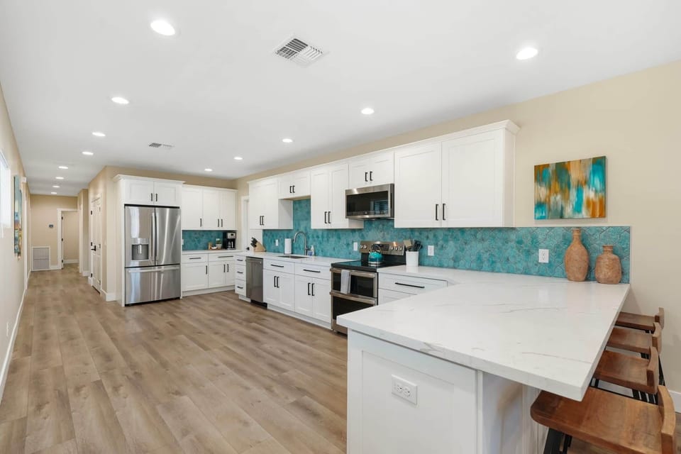 Expansive quartz island with breakfast bar seating connects the whole group.