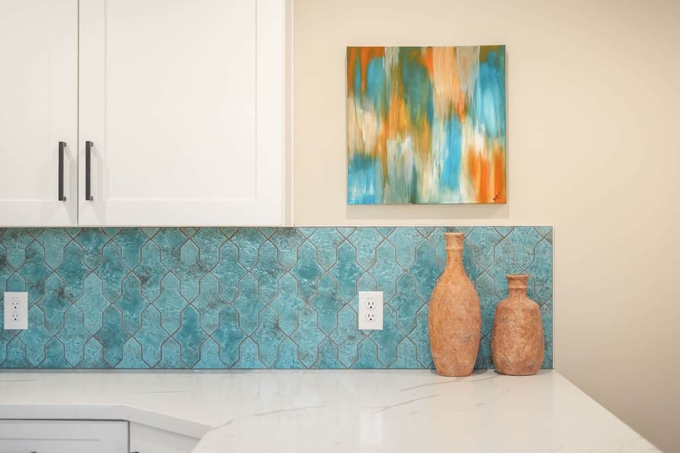 Beautiful textured teal backsplash pairs perfectly with custom artisan decor.