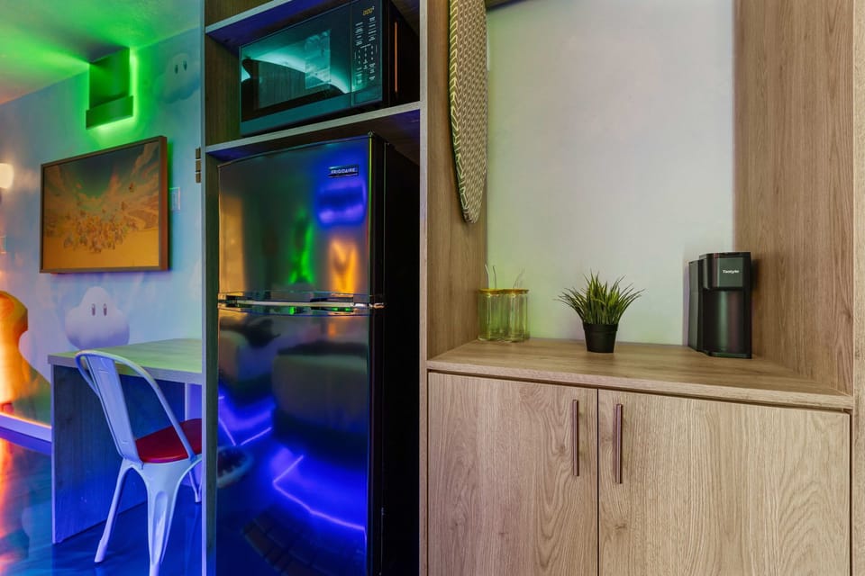 Compact kitchen area with a fridge, microwave, and coffee maker in a modern setting
