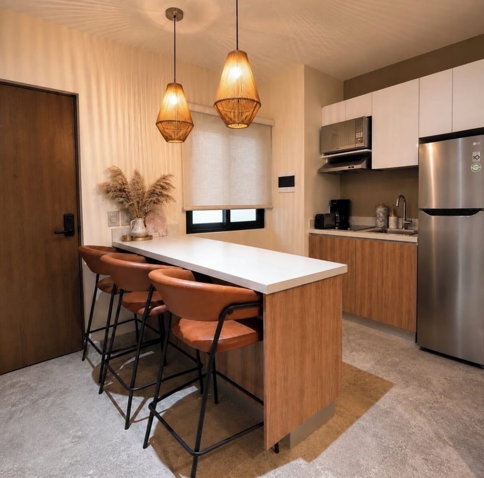 Modern kitchen with island seating and full appliances.