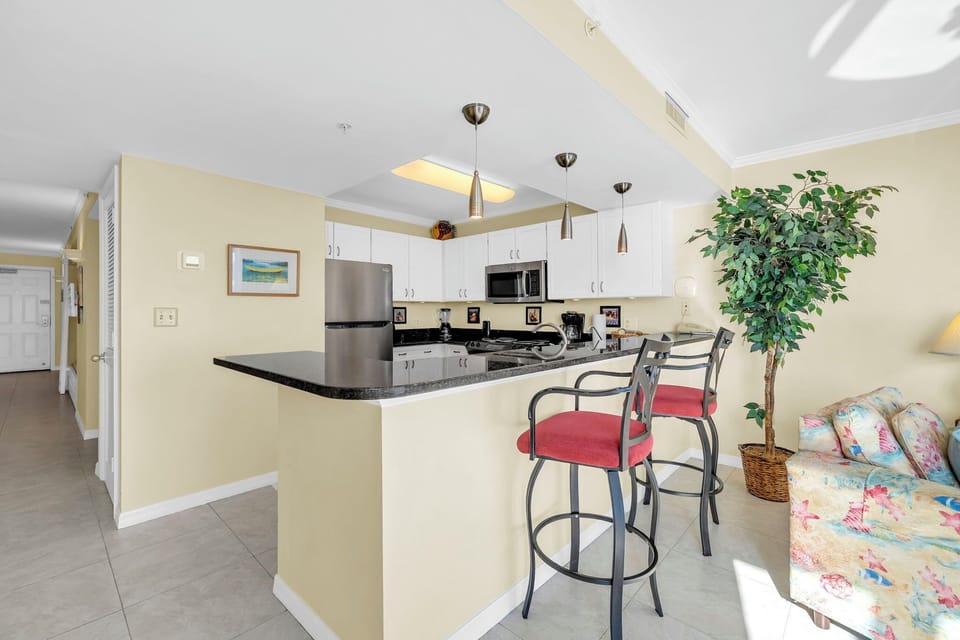 Cook and connect in your open-concept kitchen featuring granite countertops, stainless steel appliances, and a breakfast bar perfect for morning coffee.