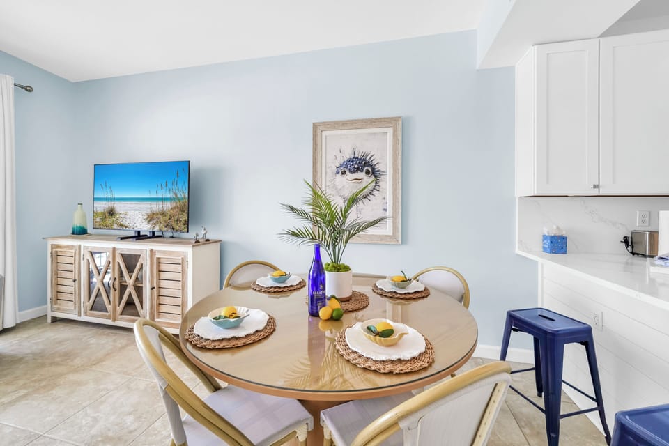 Gather around your bright dining table for meals together, with coastal artwork and modern kitchen just steps away.