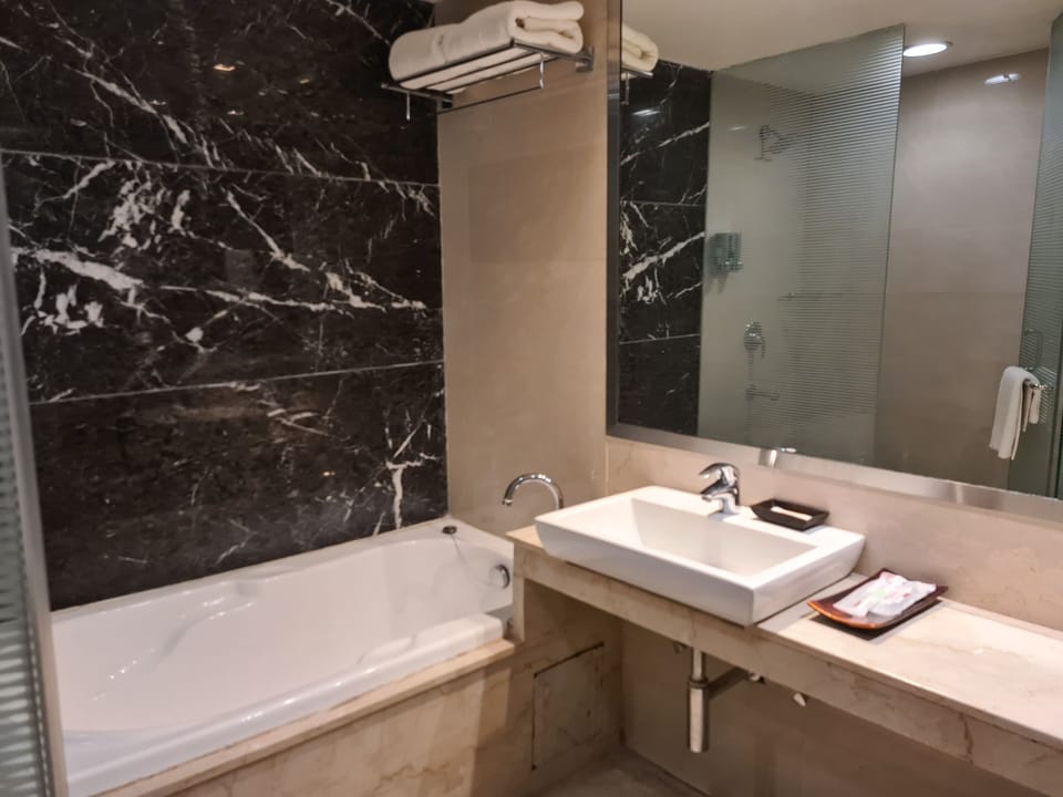 Deluxe Room, 1 King Bed | Bathroom | Combined shower/tub, free toiletries, hair dryer, slippers