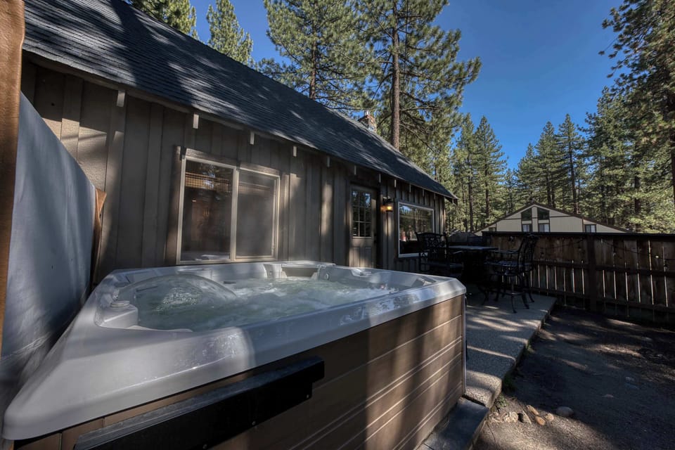 Backyard Area: Outdoor dining, fire pit table, hot tub, fenced wooden patio.