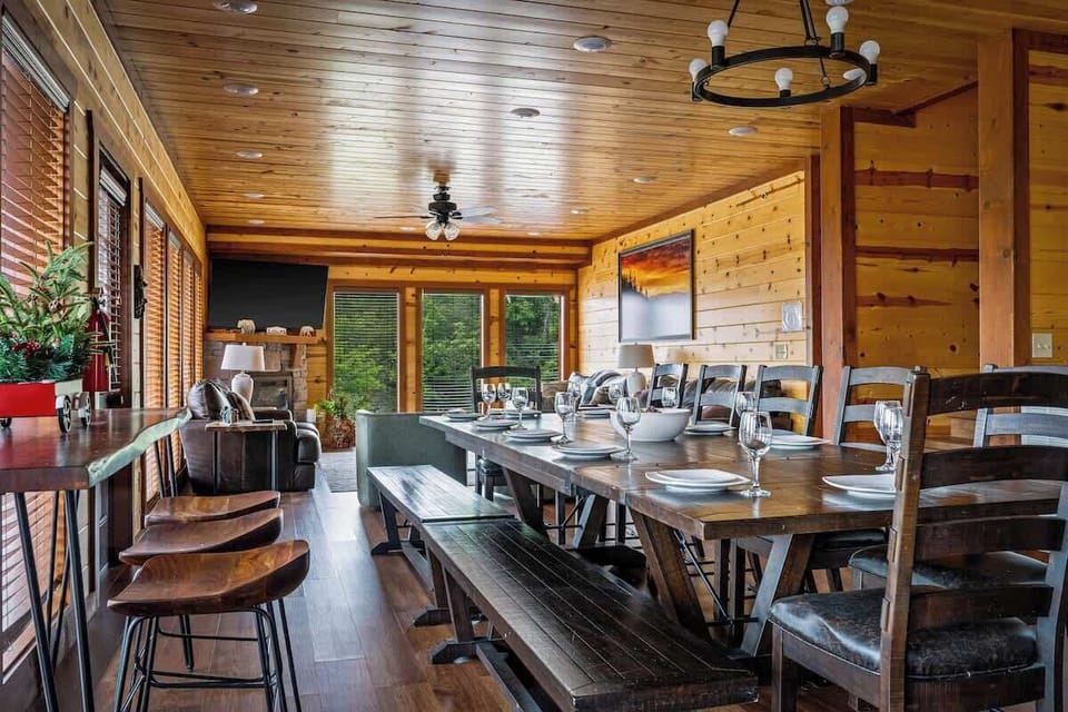 Rustic open-concept dining room with forest views and cozy lodge charm