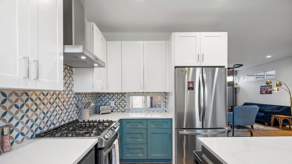 Stainless steel appliances and a bold geometric backsplash bring modern flair to the kitchen.