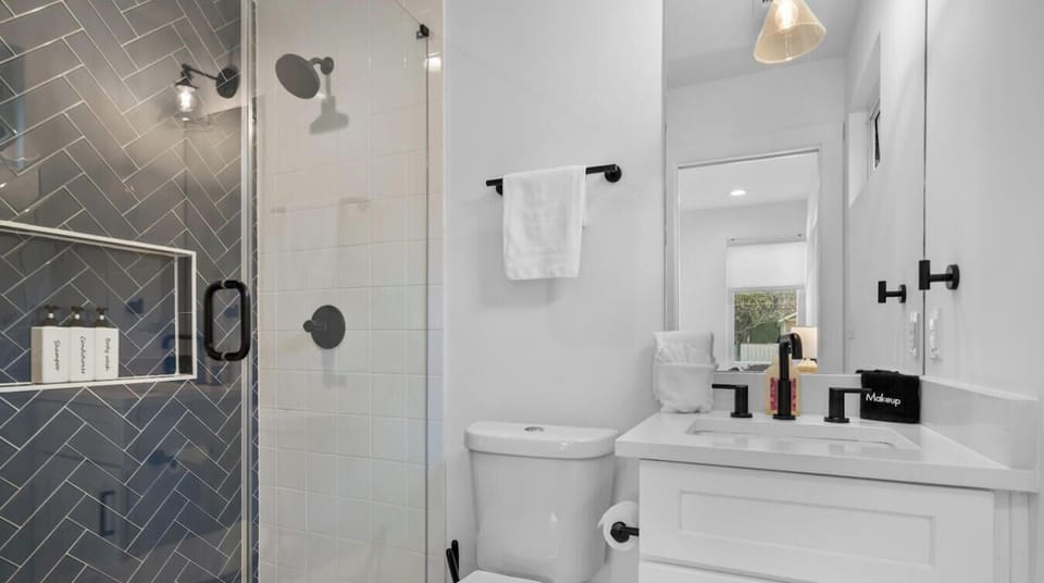 Freshen up in a sleek walk-in shower with herringbone tile and premium toiletries.