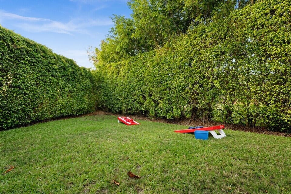 Outdoor Oasis: Enjoy friendly competitions on the lawn with cornhole and lush green privacy!