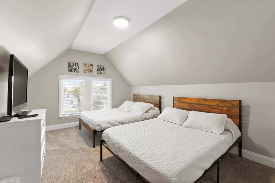Light-filled bedroom w/ a bed, soft carpet & a warm, welcoming feel.
