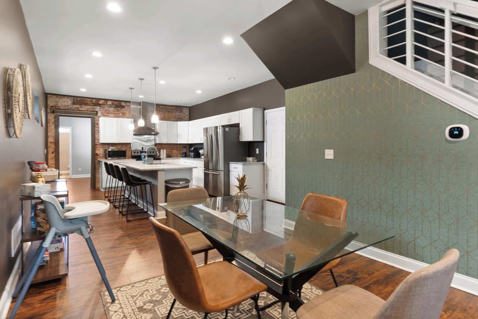 Open-concept dining & kitchen area w/ a long table, perfect for gathering w/ a group.
