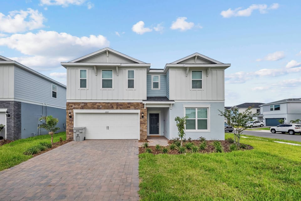 This charming home welcomes you with a stylish mix of light siding and rich stone accents, offering a warm first impression. The well-kept front yard boasts lush greenery, inviting you to relax outdoors in a peaceful setting.