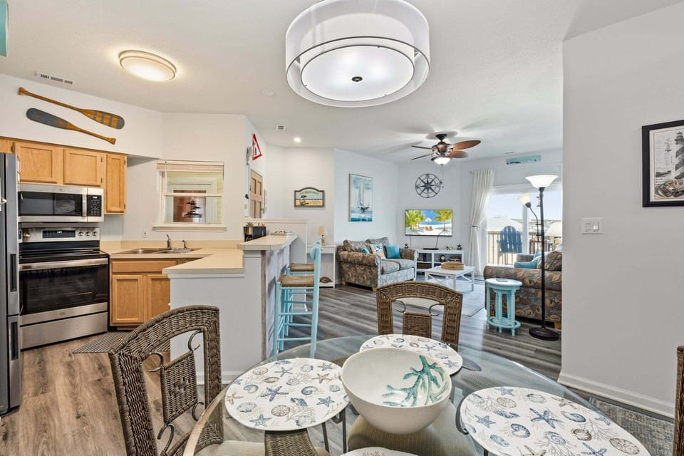 The adjacent dining area provides a welcoming space for shared meals, whether it's a quick breakfast before the beach or a full family dinner.