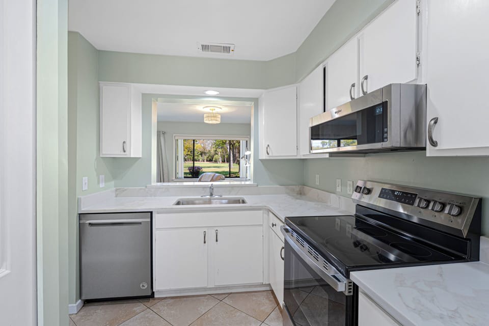 There's plenty of prep space for quick breakfasts or family dinners, and the open pass-through connects you to the dining and living areas—so you're always part of the conversation. Natural light from the window keeps the space bright throughout the day, making it as inviting as it is practical.