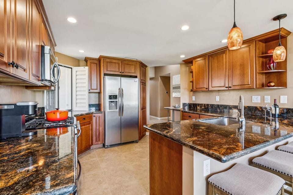 Bright kitchen w/ granite counters, bar seating & stainless appliances for easy meals