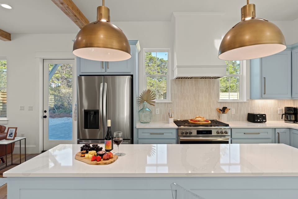Beautifully appointed kitchen with quartz counters, designer lighting, and plenty of space to prep and gather.