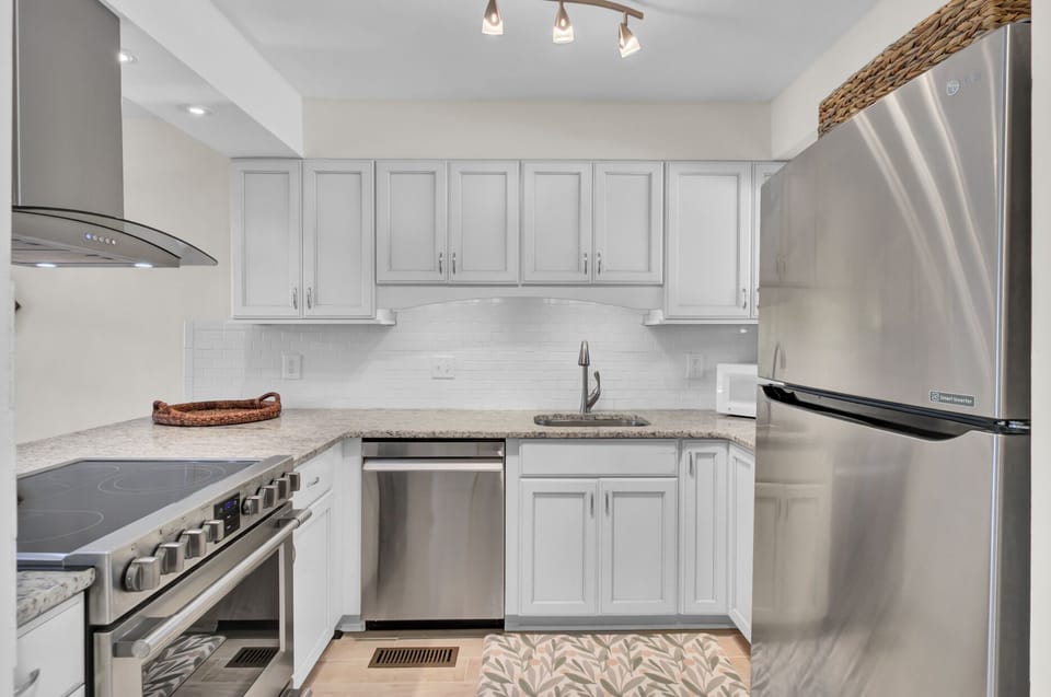 Bright white kitchen with granite counters, subway tile, and everything set up for easy Charleston cooking.