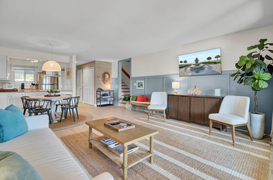 Bright coastal‑inspired living room with relaxed seating, natural textures, and easy flow to the screened porch.