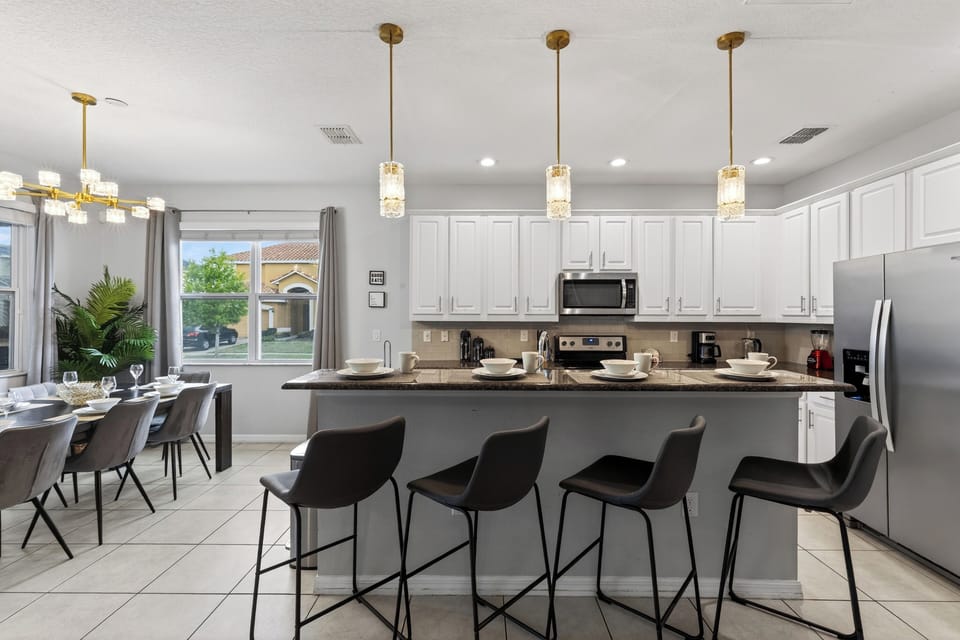 Bright, open kitchen with a spacious island and bar seating—perfect for quick breakfasts, snack breaks, and easy family dinners.