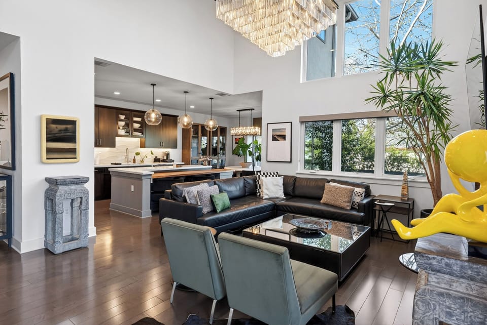 Spacious living room with soaring ceilings, oversized windows, and a sleek fireplace that anchors the space.