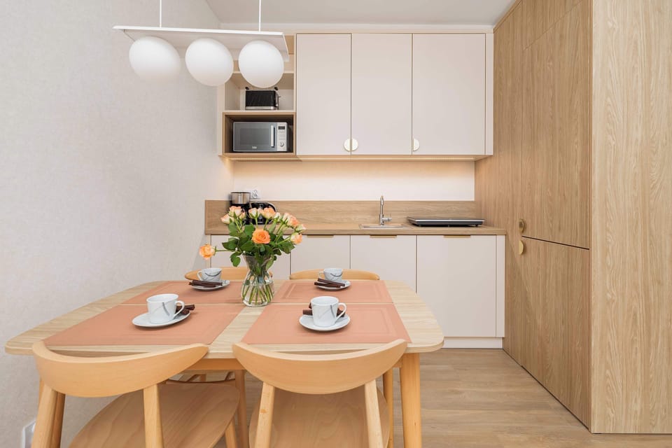 Functional kitchenette with modern cabinets and essential appliances, ideal for preparing meals.