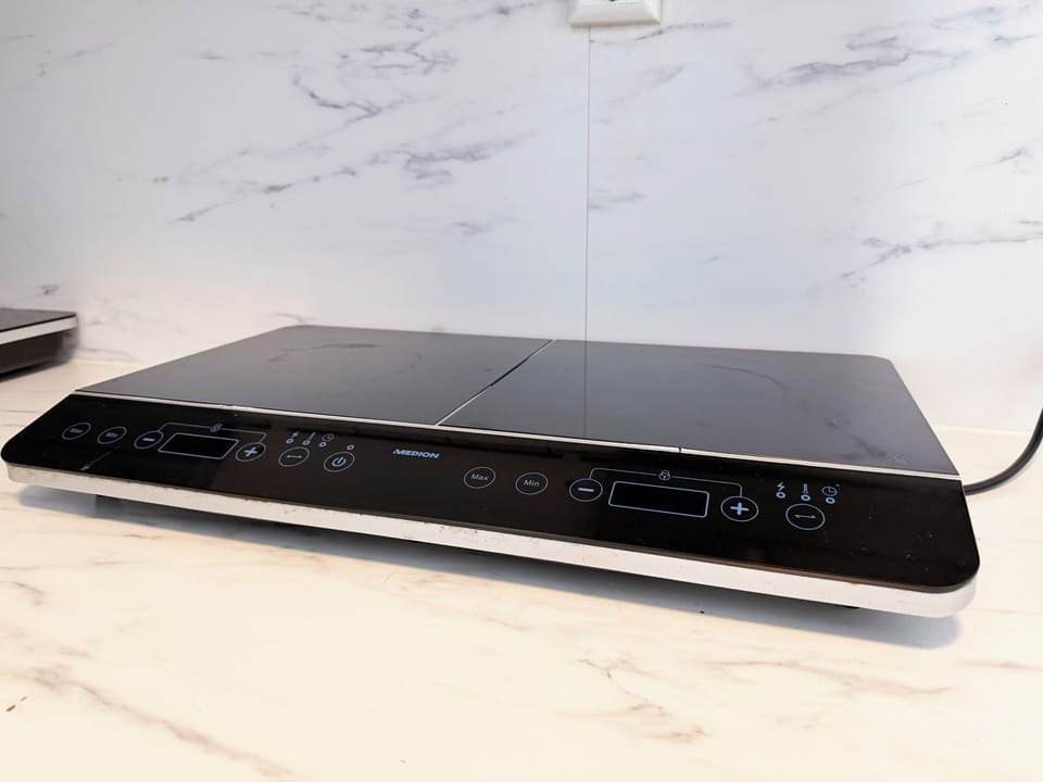 Modern induction cooktop with touch controls, sleek black surface, and minimalist design, ideal for easy and efficient cooking.