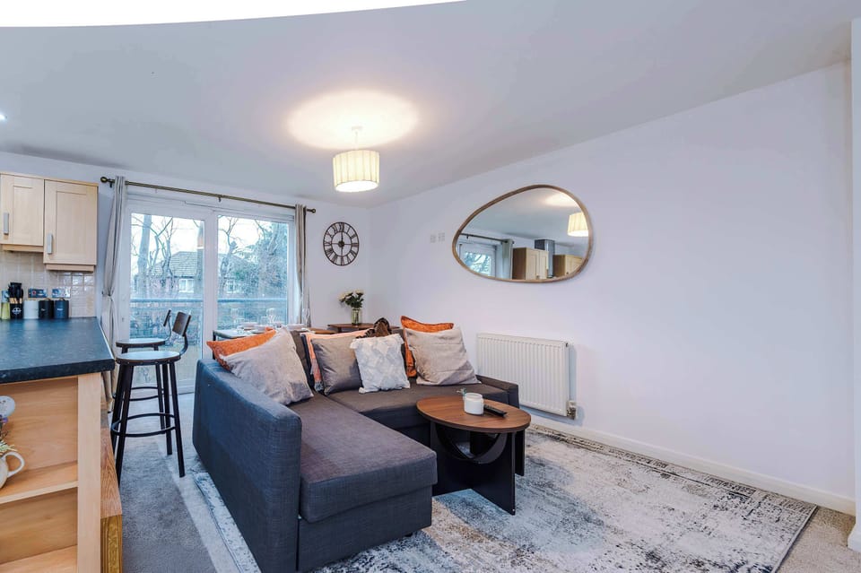 Living Room: Bright and inviting space with plush seating and leafy views from the balcony!