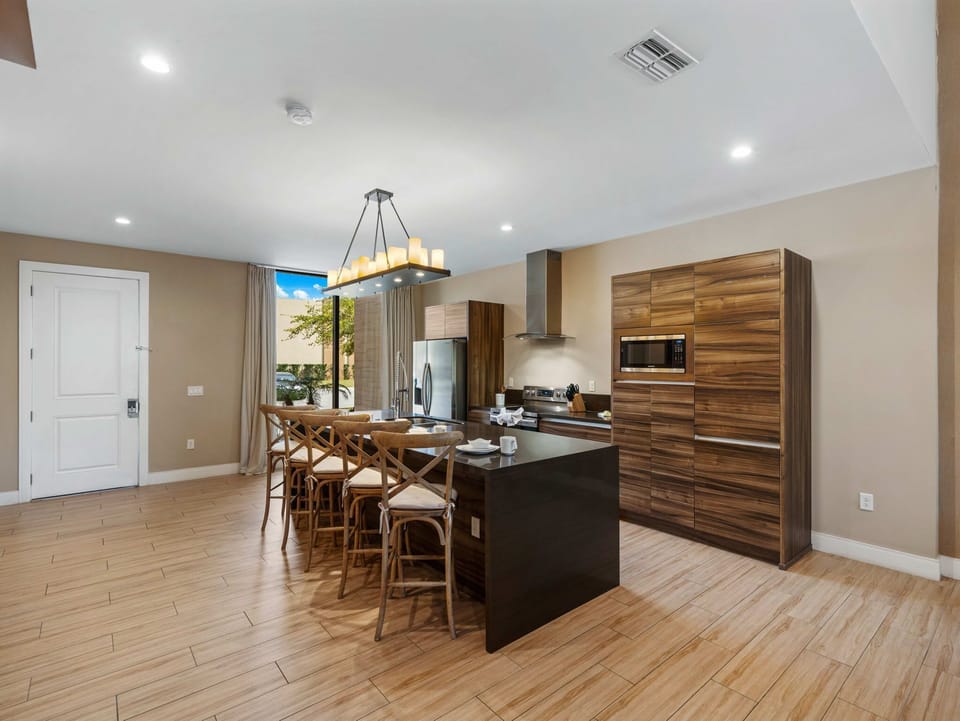 Modern kitchen with wood cabinetry and a large island featuring seating for five.