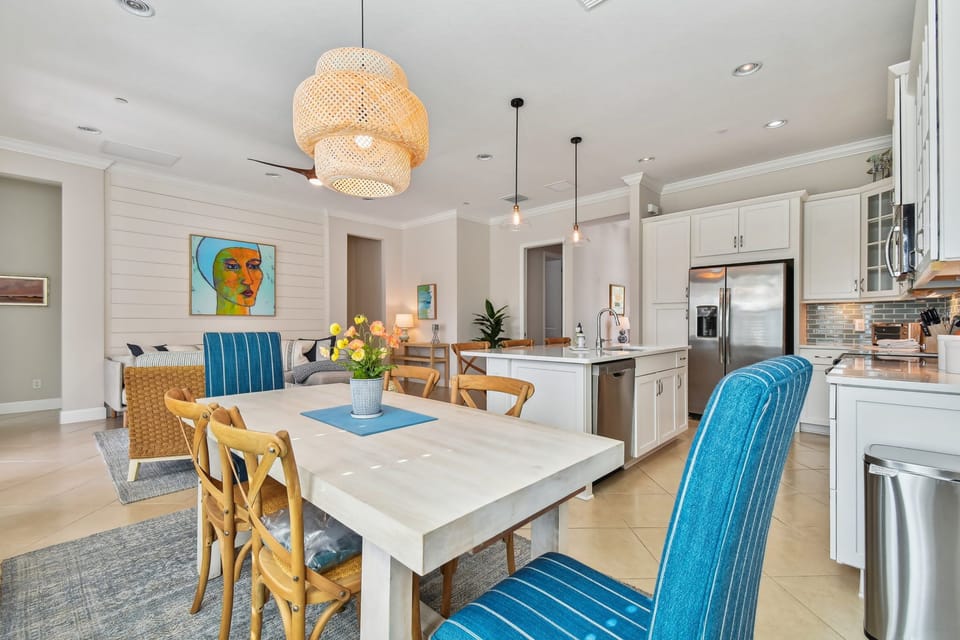Your open-concept kitchen flows into a bright dining space where coastal colors and warm wood create the perfect gathering spot for meals.