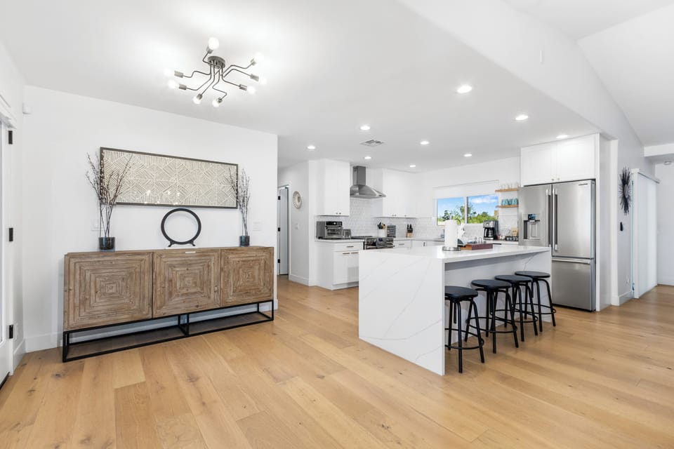 Step into your modern kitchen with sleek white cabinets, stainless steel appliances, and a spacious island where you can gather.