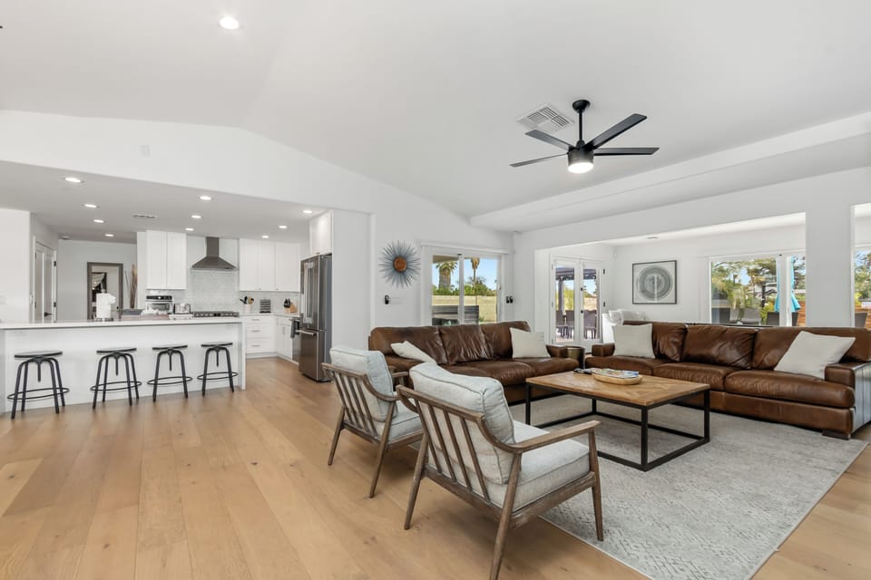 Relax in this open-concept living space where modern comfort meets style. Plush leather sofas and sleek kitchen create your perfect home base.