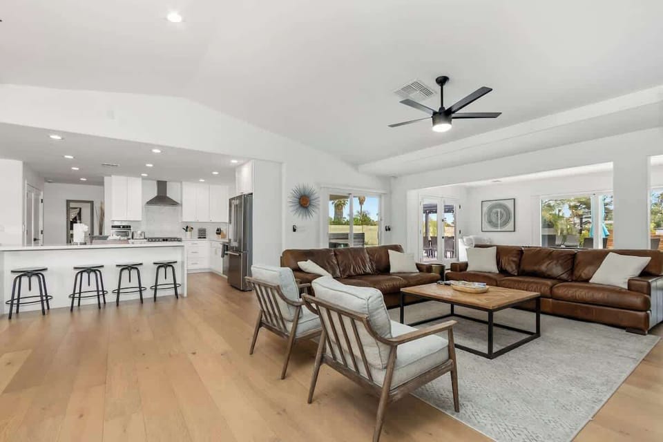 Relax in this open-concept living space where modern comfort meets style. Plush leather sofas and sleek kitchen create your perfect home base.