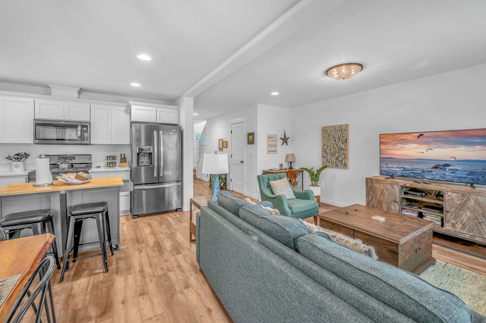 Your open-concept retreat seamlessly blends modern kitchen and cozy living space, perfect for relaxing after beach adventures.