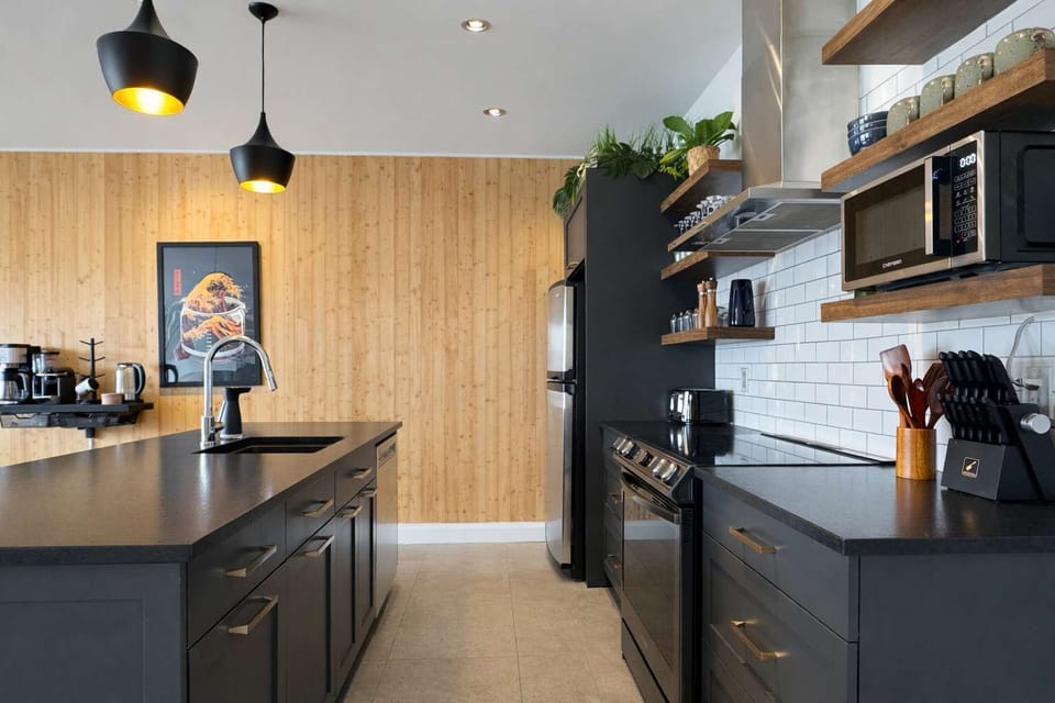 Cuisinez en toute simplicité dans cette cuisine contemporaine et lumineuse, dotée d'armoires élégantes et d'un dosseret en tuiles "subway". Le grand îlot et les étagères ouvertes allient style et espace pour tous vos besoins culinaires.