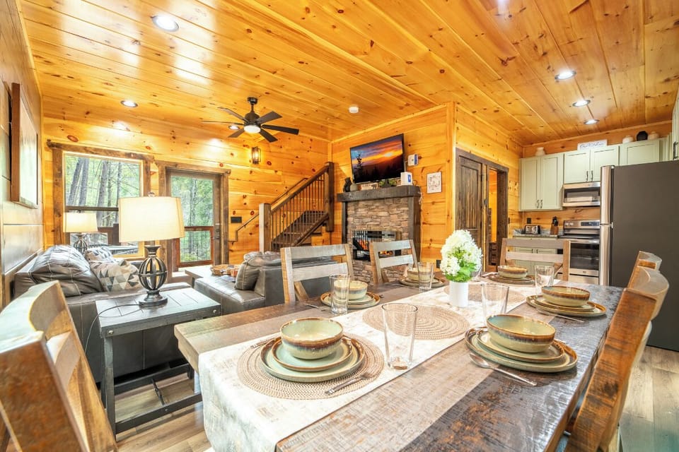Step into your cozy cabin retreat where rustic wood beams frame the perfect space for memorable meals and relaxing evenings by the fireplace.