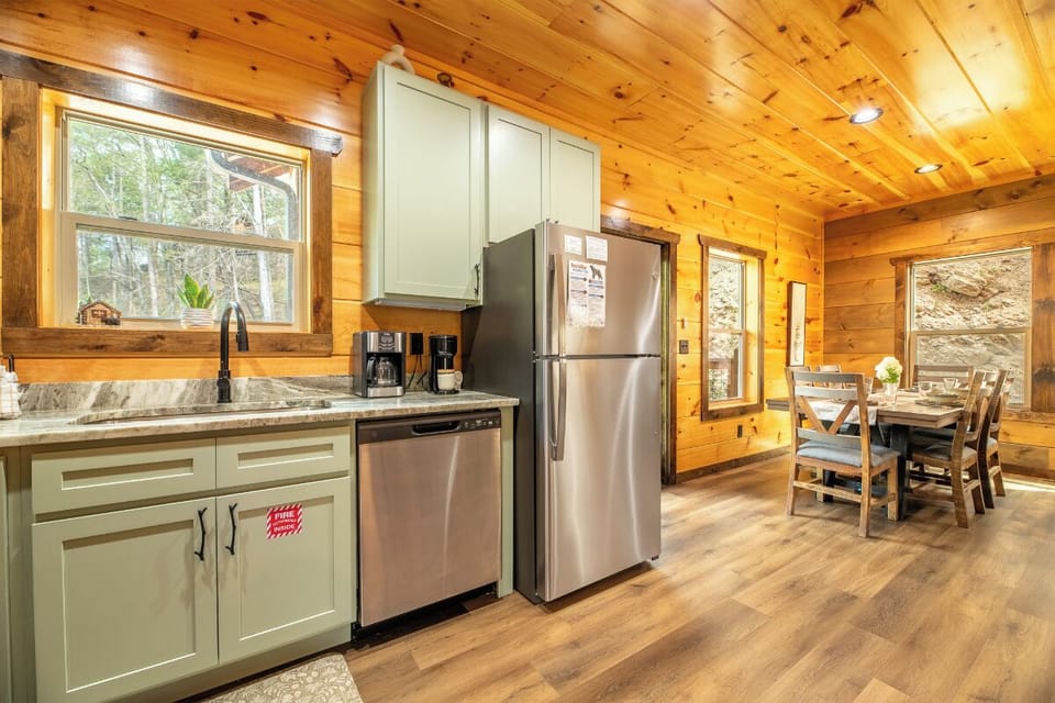 Your rustic cabin kitchen blends modern convenience with cozy charm, featuring granite counters and warm wood beams overhead.