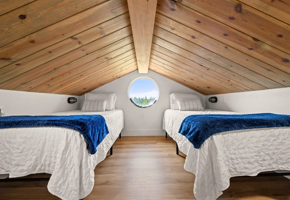 This cozy sleeping nook with twin beds feels tucked away and inviting, making it a comfortable spot to wind down at the end of the day.