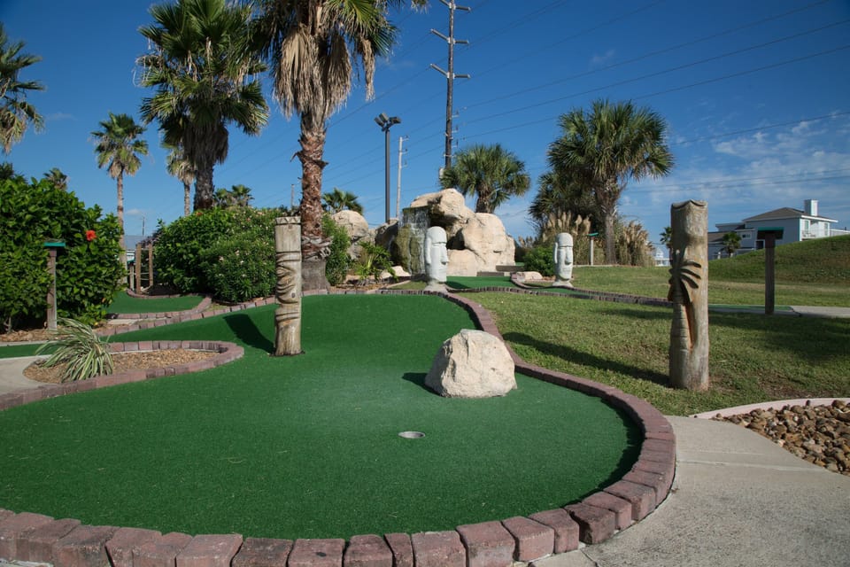 Challenge friends to a fun round of mini golf, complete with tropical decor and lush greenery.