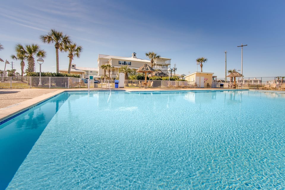 Relax poolside with palm trees swaying softly in the breeze.