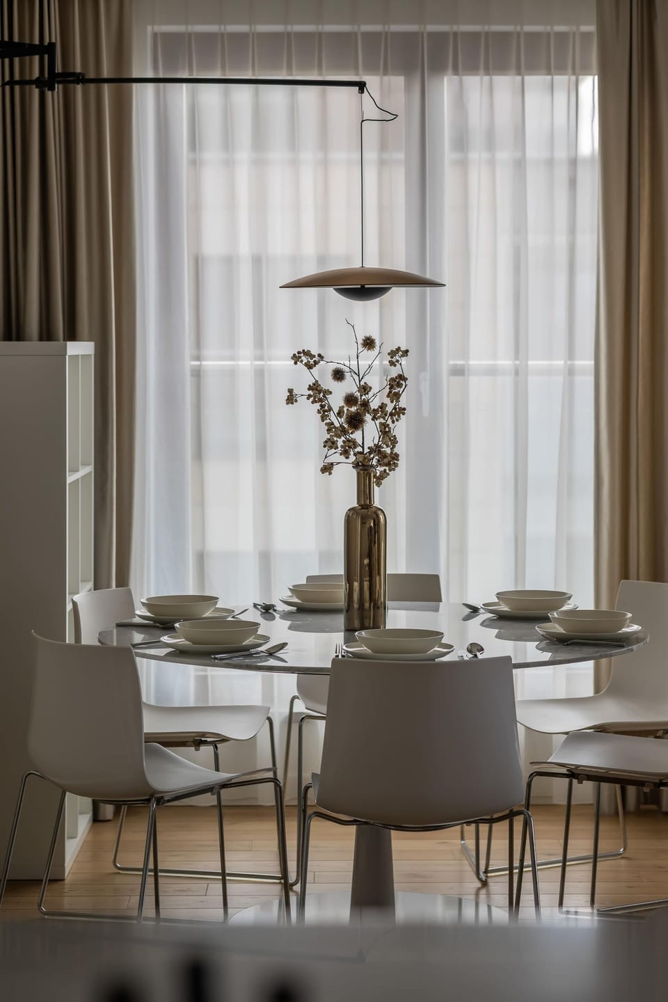 A dining area near a window with curtains offers a pleasant place for meals. Natural light enhances the ambiance.