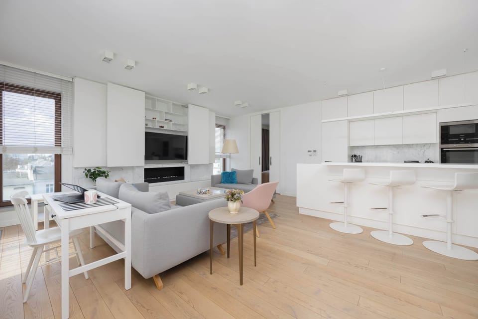 A sleek kitchenette island with bar seating offers both functionality and a social hub. Clean lines and light tones emphasize a contemporary design.
