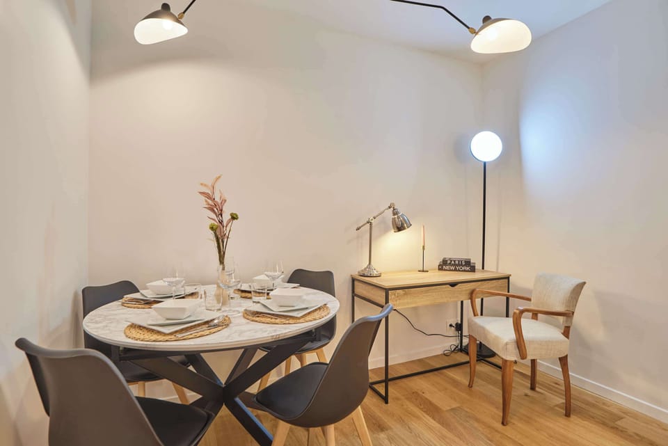 Salon chaleureux avec canapé, table basse, espace repas, smart TV, espace bureau