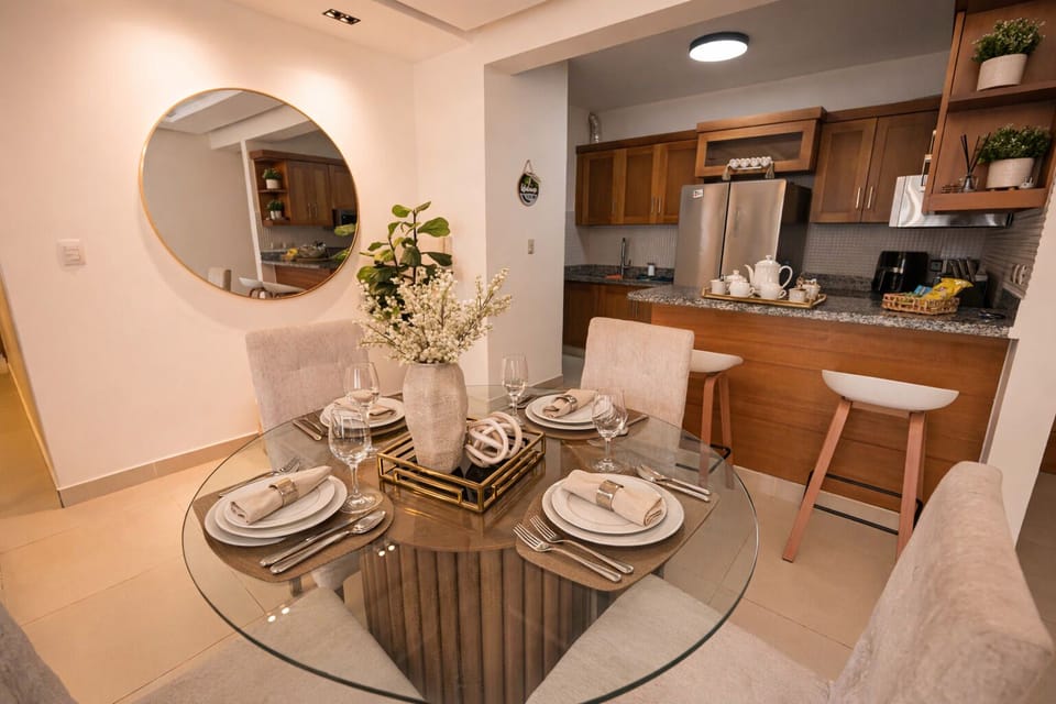 Elegant dining area Cozy round glass table with four upholstered chairs and a chic centerpiece